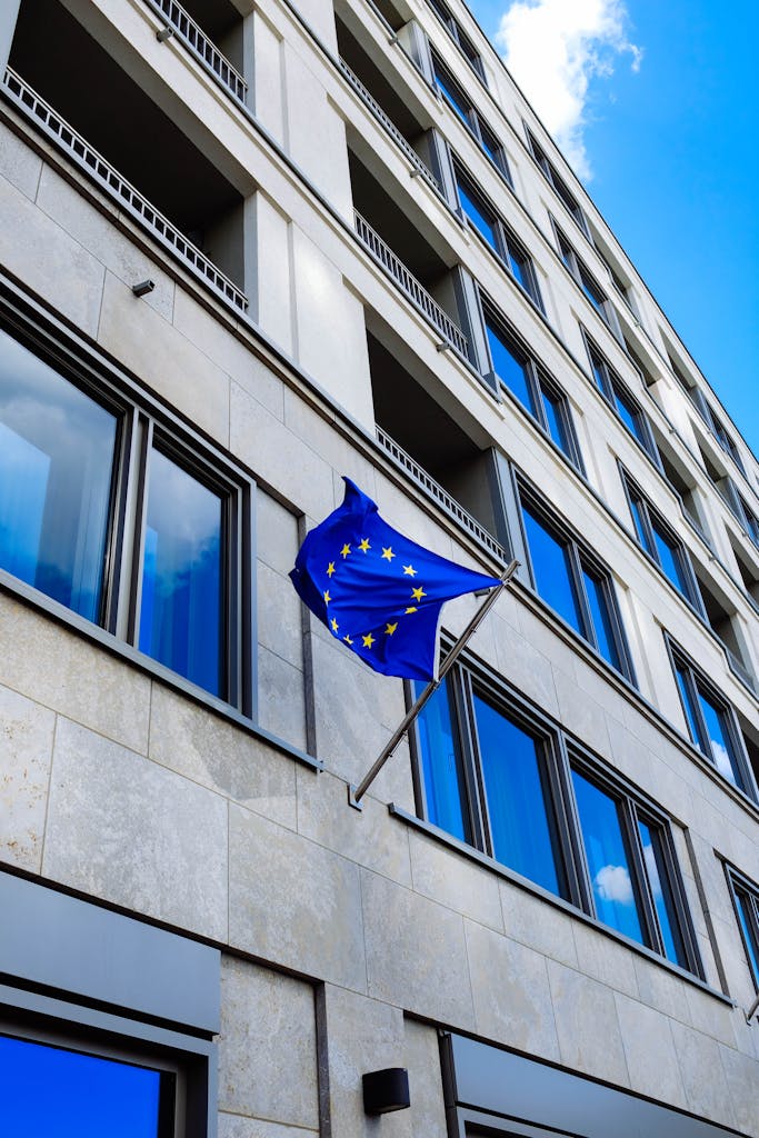 Angle view of a modern building facade with European Union flag waving.