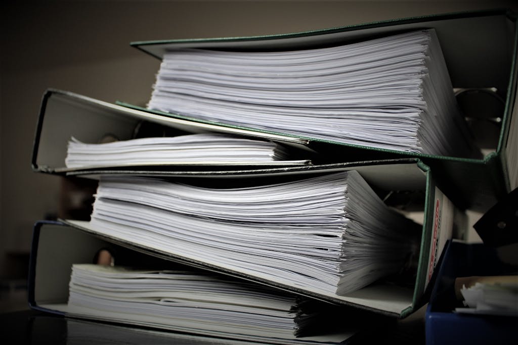 Close-up of stacked binders filled with documents for office or educational use.